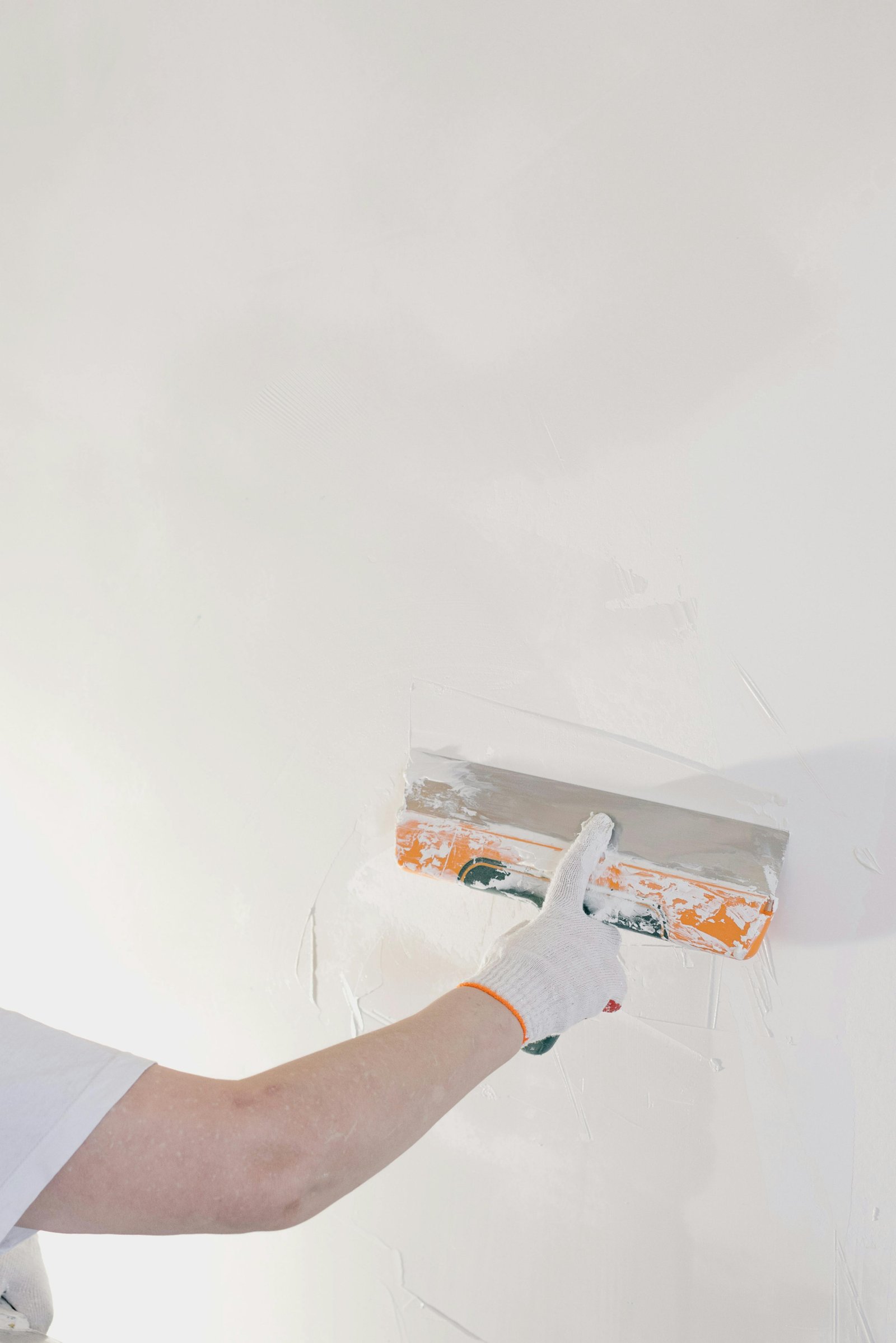 Hand applying Marmorino plaster with a long trowel on a white wall — MarkOn® Walls atelier, Vicenza-trained