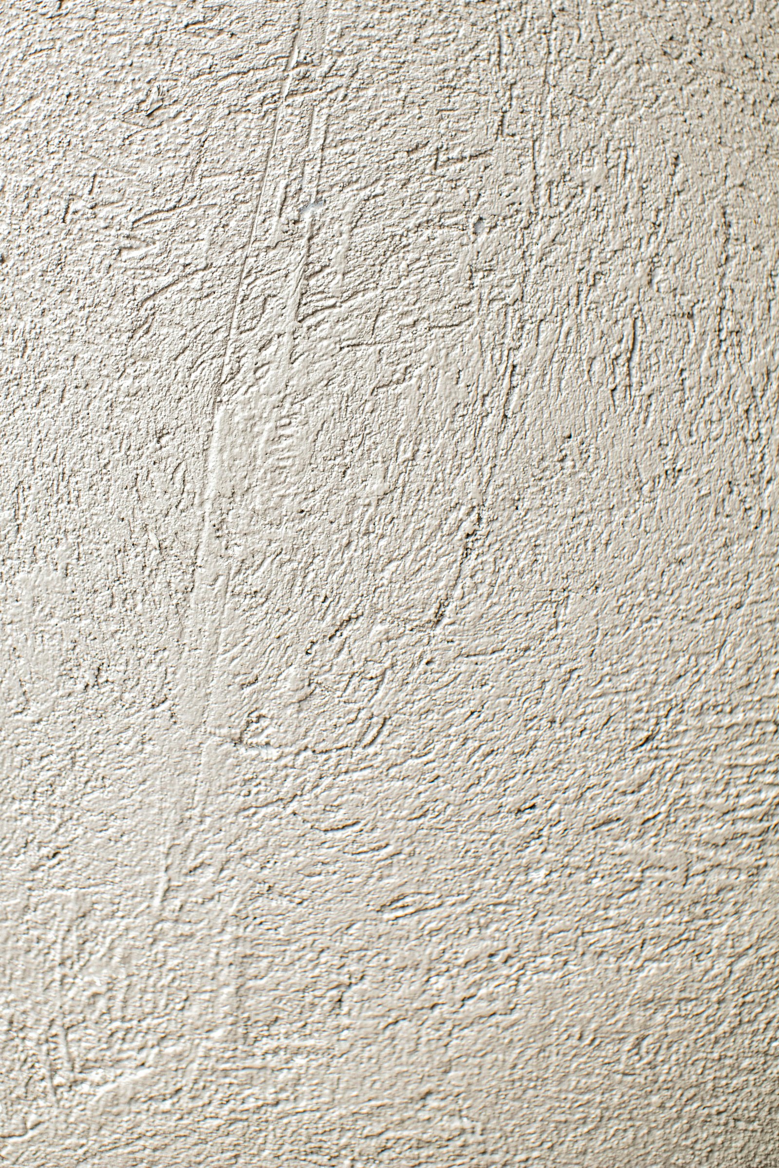 Hand-troweled plaster macro detail — visible trowel marks and mineral variation in monochrome cream — MarkOn® Walls material specimen