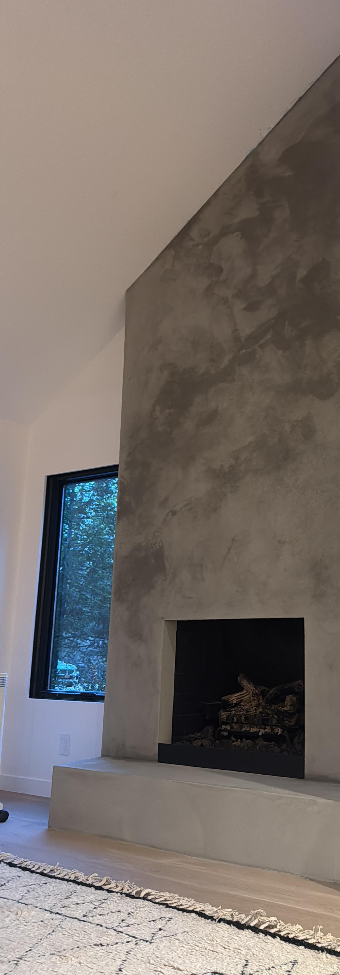 East Hampton fireplace hearth in smoked charcoal Tadelakt — burnished Moroccan lime, hand-polished by Vlad Markov for MarkOn® Walls